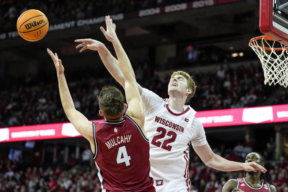 Rutgers' Paul Mulcahy (4) and Wisconsin's Steven Crowl (22) go after a rebound during the second half of an NCAA college basketball game Saturday, Feb. 18, 2023, in Madison, Wis. (AP Photo/Andy Manis)