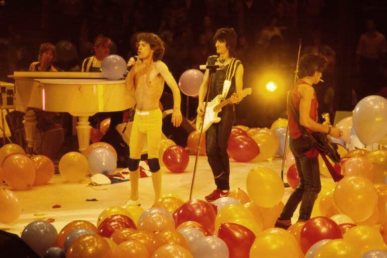 Mick Jagger, Ronnie Wood y Keith Richards, actúan entre globos en el escenario durante la gira The Rolling Stones American Tour 1981, lanzada para mostrar en vivo las canciones de Tattoo You (en Brendan Byrne Arena, East Rutherford, Nueva Jersey, en noviembre de 1981. También se ven, en el extremo izquierdo, a Ian McLagan en el órgano y al cofundador Ian Stewart al piano