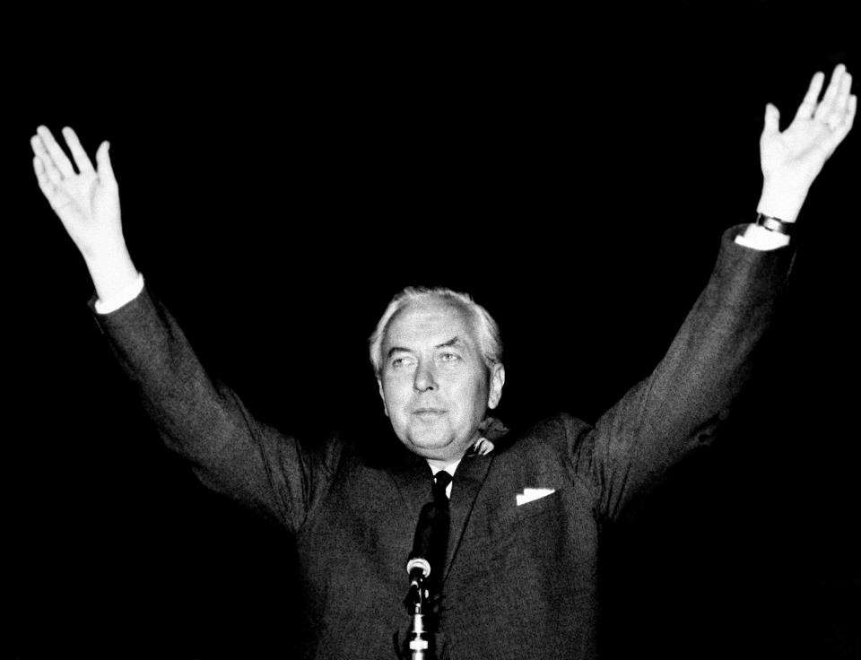 FILE - Britain's Labour Party leader Harold Wilson raises his hands after retaining his seat in the House of Commons and winning the general election, outside the ballot counting rooms rooms at the Huyton Secondary School in Huyton, Lancashire, England, Oct. 15, 1964. Britain’s upcoming general election on July 4, 2024 is widely expected to lead to a change of government for the first time in 14 years. In 1964, the Conservative Party had been in power for 13 years and was on its fourth prime minister. The election was a race between the aristocratic Douglas-Home and Labour leader Harold Wilson, a young politician who was buzzing with ideas such as the need to harness the “white heat of technology” to modernize the ailing British economy. (AP Photo/File)