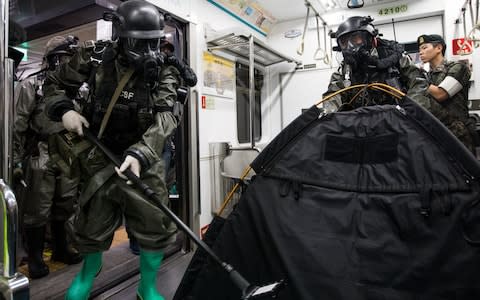 Soldiers wearing gas masks perform inspections inside a subway train during an anti-terror drill on the sidelines of the Ulchi Freedom Guardian (UFG) military exercises  - Credit: Bloomberg