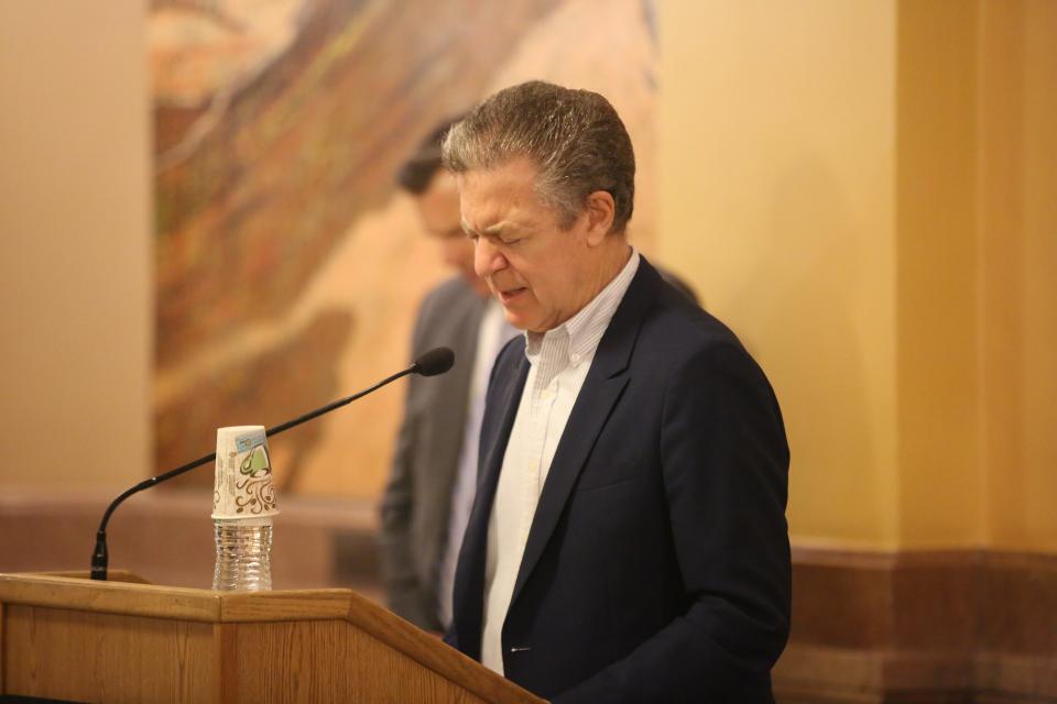 Sam Brownback prays for the nations of the world, including Israel and Ukraine, during a National Day of Prayer event Thursday at the Statehouse.