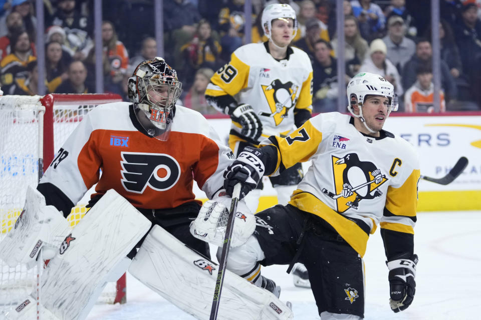 Pittsburgh Penguins' Sidney Crosby, right, collides with Philadelphia Flyers' Carter Hart during the first period of an NHL hockey game, Monday, Dec. 4, 2023, in Philadelphia. (AP Photo/Matt Slocum)