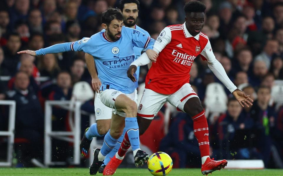 Arsenal's Bukayo Saka in action with Manchester City's Bernardo Silva - Action Images via Reuters