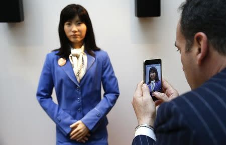 Visitors takes photos of communications android 'Chihira Kanae' (C) at an information counter at the International Tourism Trade Fair (ITB) in Berlin, Germany, March 9, 2016. REUTERS/Fabrizio Bensch