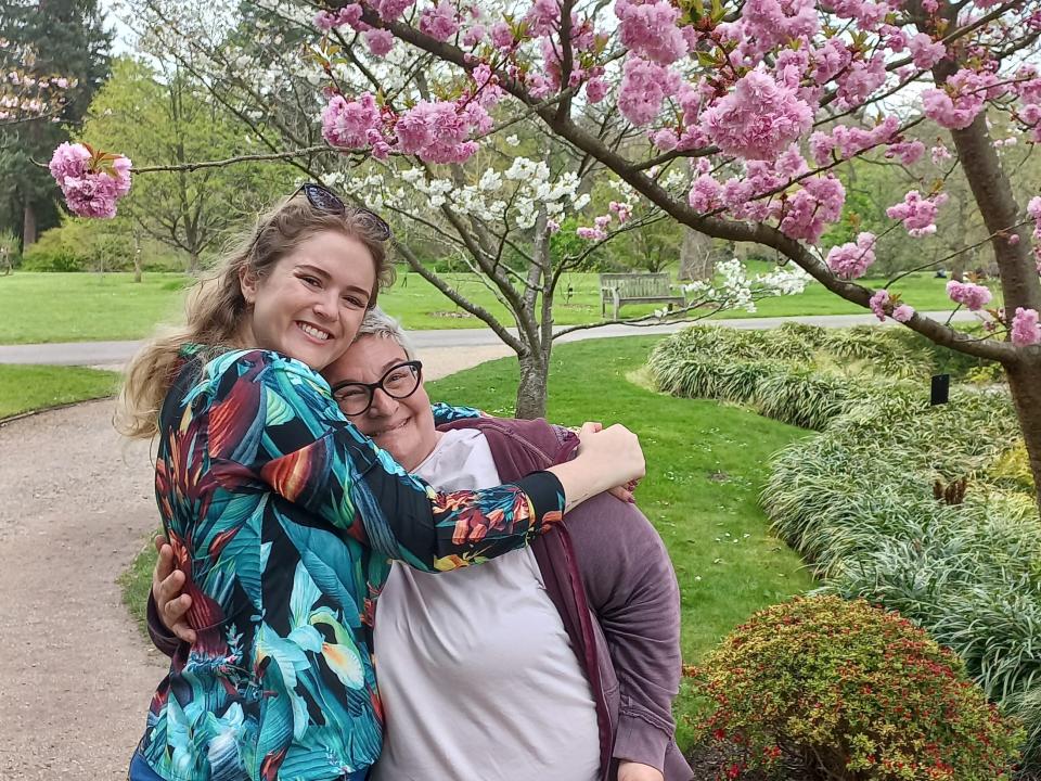 Tayla and her friend Penny walking in a garden.