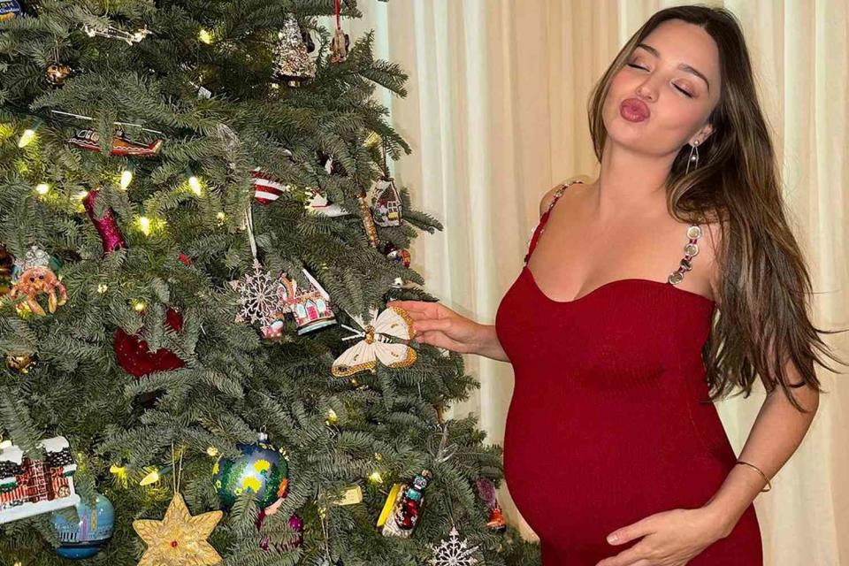 <p> Miranda Kerr/Instagram</p> Miranda Kerr poses by a Christmas tree.