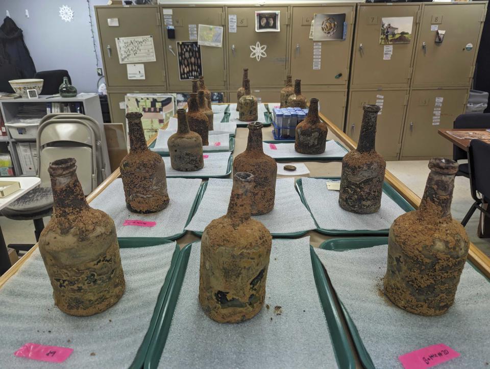 18th-century glass bottles that contained fruit sit inside an archaeology lab near George Washington's residence in Mount Vernon, Va., Monday, June 17, 2024. Earlier this year, archeologists unearthed dozens of glass bottles, some of which contained cherries and berries, from the mansion cellar of America's first president. (AP Photo/Nathan Ellgren)