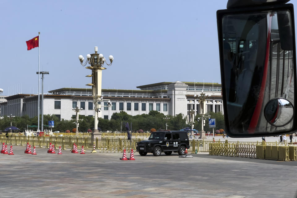 A police vehicle is parked near a China national flag waving in Tiananmen Square in Beijing, Monday, June 3, 2024. China has quashed large-scale commemorations of Tuesday's 35th anniversary of Beijing's Tiananmen Square crackdown within its borders. But outside the country, commemorative events have grown increasingly crucial for preserving memories of the 1989 bloodletting, in which government troops opened fire on pro-democracy protesters resulting in hundreds, if not thousands, dead. (AP Photo/Andy Wong)