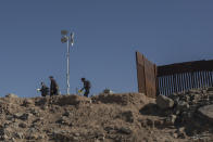 Nicaraguan migrants Benjamin Villalta, Edgar Sequeira and Emanuel Mendoza, walk on the US-Mexico border, in Algodones, Baja California, Mexico, Thursday, Dec. 2, 2021. Villalta hoped that documents certifying that he was politically persecuted by the government of Nicaragua President Daniel Ortega and a victim of torture would help him win asylum in the U.S. before they started returning asylum seekers to Mexico again. (AP Photo/Felix Marquez)