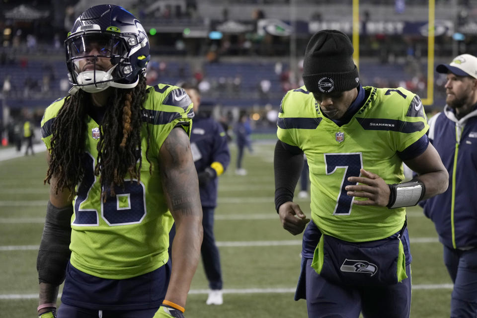 Seattle Seahawks safety Ryan Neal, left, and quarterback Geno Smith walk off the field after an NFL football game against the San Francisco 49ers in Seattle, Thursday, Dec. 15, 2022. (AP Photo/Stephen Brashear)