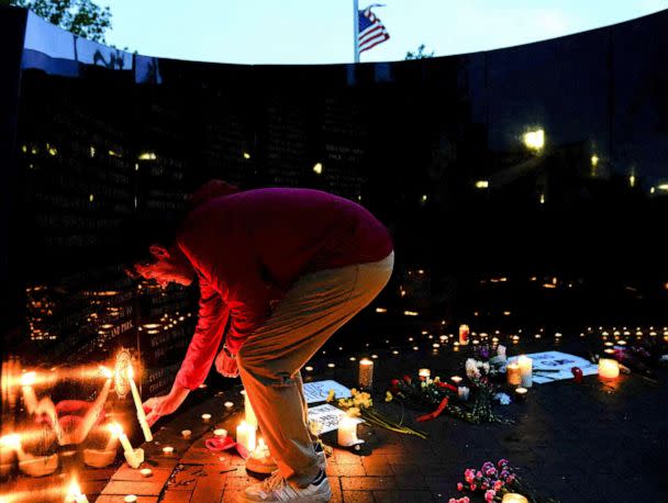 PHOTO: A community member lights a candle at a memorial site near the parade route the day after a mass shooting at a Fourth of July parade in the Chicago suburb of Highland Park, Ill., July 5, 2022.   (Cheney Orr/Reuters)