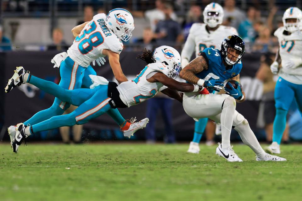 Jacksonville Jaguars wide receiver Elijah Cooks (84) is tackled by Miami Dolphins cornerback Cam Smith (24) during the third quarter of a preseason matchup Saturday, Aug. 26, 2023 at EverBank Stadium in Jacksonville, Fla. The game was suspended in the fourth after Miami Dolphins wide receiver Daewood Davis (87) was injured on a play with the Jaguars leading 31-18.