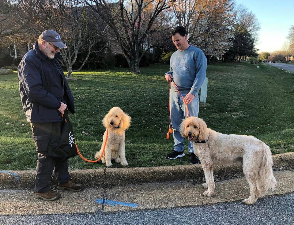 From left to right, Samuel H. Jones III and his Goldendoodle Magnolia visit with Jeff Mathis and his Goldendoodle Hank on the corner of Hogan's Alley and Inverness Drive in Chester, Va. on March 7, 2023.