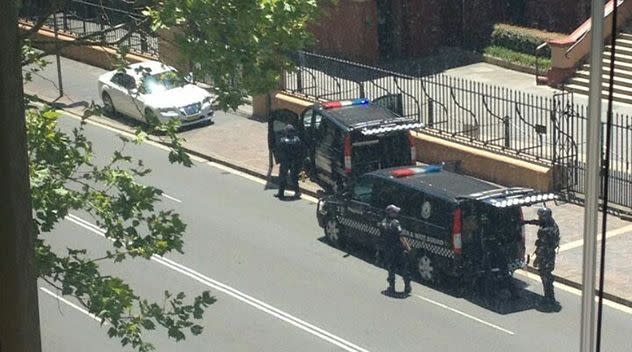 Office workers peered on as the riot squad negotiated with the man outside NSW Parliament House. Photo: Carrissa Mills/Yahoo7