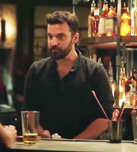 Jake Johnson standing behind a bar