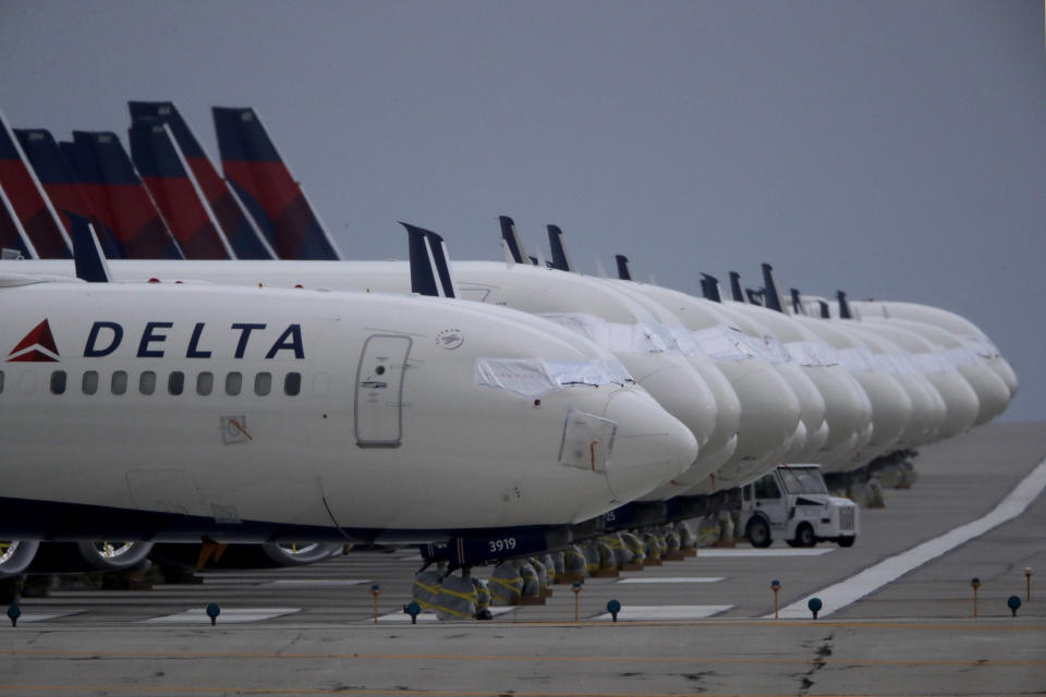 FILE - In this May 14, 2020 file photo, several dozen mothballed Delta Air Lines jets are parked on a closed runway at Kansas City International Airport in Kansas City, Mo. Delta Air Lines will require new employees to be vaccinated against COVID-19 starting Monday, May 17, 2021. The airline won’t impose the same requirement on current employees, more than 60% of whom are vaccinated, a Delta spokesman said Friday. Delta has about 74,000 employees. (AP Photo/Charlie Riedel, File)