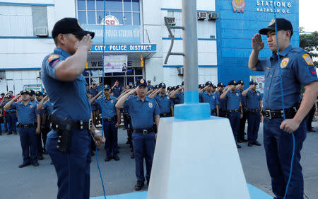 Policemen take part in a flag-raising ceremony at the grounds of Station 6, Batasan Police Station, in Quezon City, Metro Manila, Philippines December 4, 2017. REUTERS/Erik De Castro