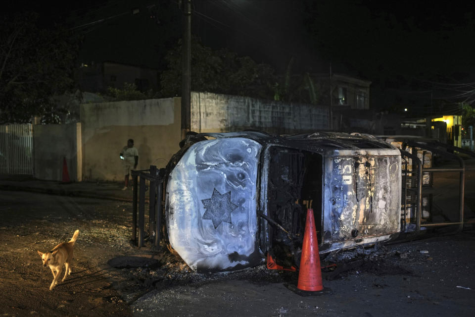 A damaged Veracruz state police patrol car lays on its side, burned by residents protesting the death of Brando Arellano Cruz, fatally shot by police after he failed to pull over, in Lerdo de Tejada near Veracruz, México, Saturday, Jan. 19, 2024. Four municipal police officers are under investigation in relation to the death of the young man, after the victim's neighbors staged violent protests and attempted to lynch the officers. (AP Photo/Felix Marquez)