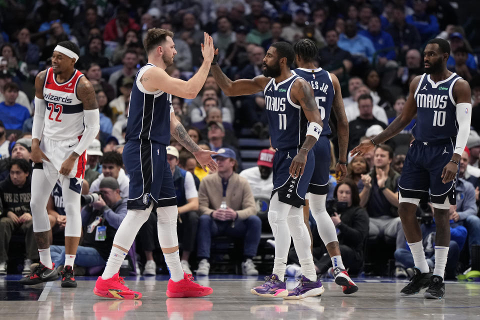 DALLAS, TEXAS - FEBRUARY 12: Luka Doncic #77 of the Dallas Mavericks is congratulated by Kyrie Irving #11 of the Dallas Mavericks during the first half against the Washington Wizards at American Airlines Center on February 12, 2024 in Dallas, Texas. NOTE TO USER: User expressly acknowledges and agrees that, by downloading and or using this photograph, User is consenting to the terms and conditions of the Getty Images License Agreement. (Photo by Sam Hodde/Getty Images)