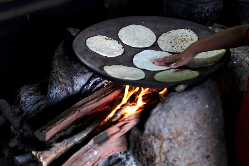 The daughter of Gonzalo Ramirez cooks tortillas at their home, in La Palmilla