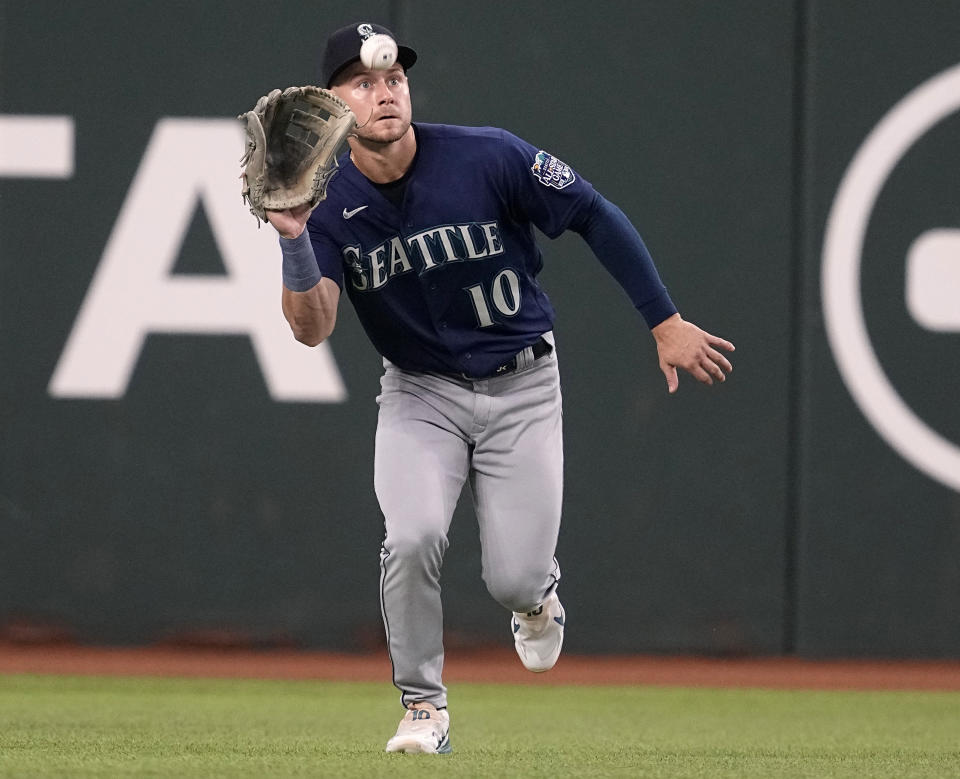 FILE - Seattle Mariners left fielder Jarred Kelenic reaches up to catch a flyout by Texas Rangers' Nathaniel Lowe in the first inning of a baseball game, Sept. 24, 2023, in Arlington, Texas. The Atlanta Braves acquired Kelenic, pitcher Marco Gonzales and infielder Evan White from the Mariners, Sunday, Dec. 3, 2023, for right-handed pitchers Cole Phillips and Jackson Kowar. (AP Photo/Tony Gutierrez, File)