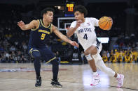 Penn State forward Puff Johnson (4) works toward the basket as Michigan forward Terrance Williams II (5) defends during the second half of an NCAA college basketball game in the first round of the Big Ten Conference men's tournament Wednesday, March 13, 2024, in Minneapolis. (AP Photo/Abbie Parr)