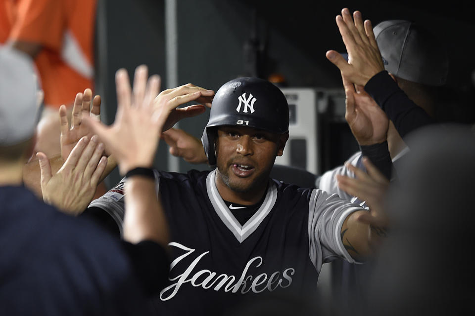 New York Yankees' Aaron Hicks is congratulated after scoring against the Baltimore Orioles on a double by Miguel Andujar during the third inning of a baseball game Sunday, Aug. 26, 2018, in Baltimore. (AP Photo/Gail Burton)