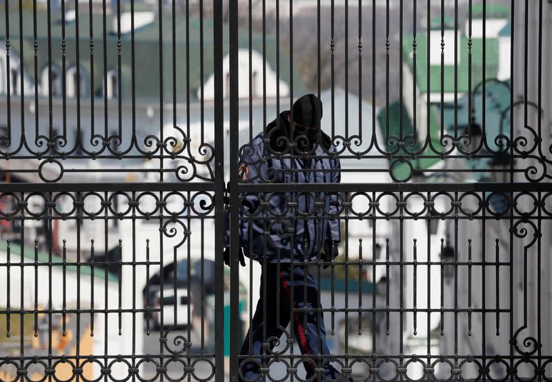 A security guard wearing a protective face mask is seen at the gate of Kiev Pechersk Lavra monastery in Kiev