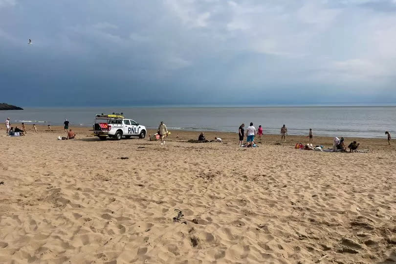 Welsh beach with people and vehicle on sand