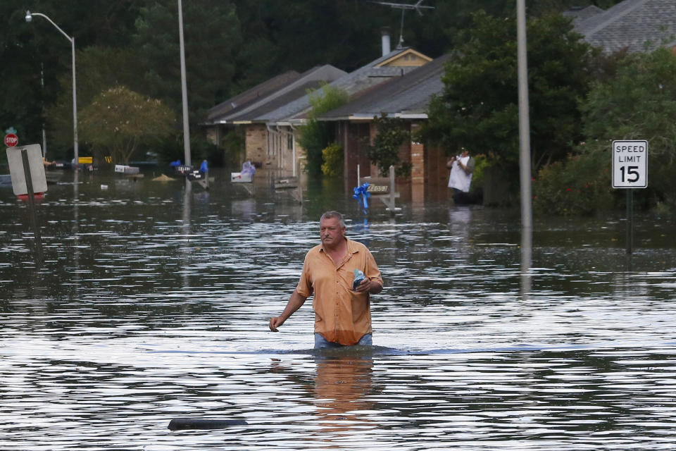 A man wades through a flooded street in Ascension Parish, Louisiana, Aug. 15, 2016. (Photo: Jonathan Bachman / Reuters)