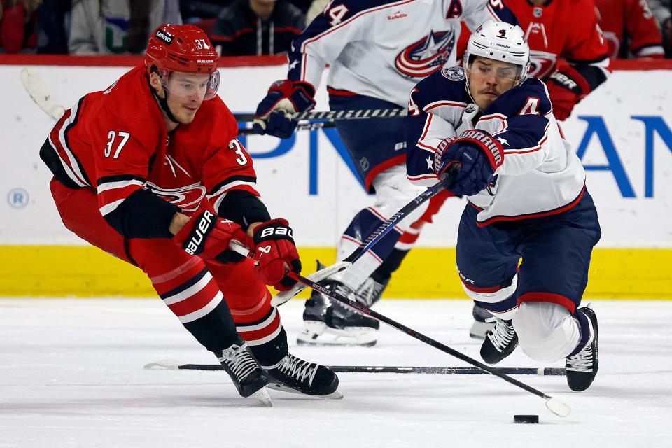 Columbus Blue Jackets' Cole Sillinger (4) dives for the puck controlled by Carolina Hurricanes' Andrei Svechnikov (37) during the first period of an NHL hockey game in Raleigh, N.C., Sunday, Nov. 26, 2023. (AP Photo/Karl B DeBlaker)