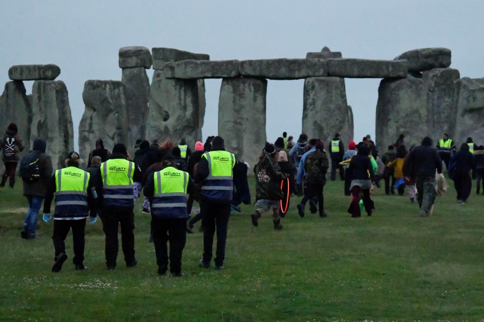 Security looks on as people run to Stonehenge (REUTERS)