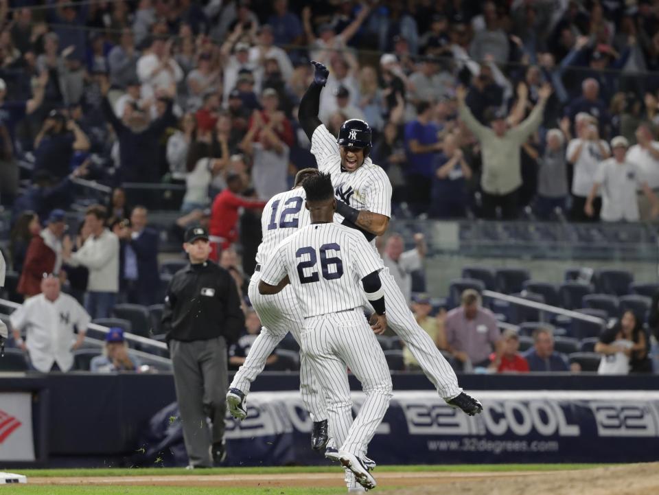 New York Yankees' Aaron Hicks celebrates with teammates Tyler Wade (12) and Andrew McCutchen (26) after hitting an RBI double during the eleventh inning of a baseball game against the Baltimore Orioles Saturday, Sept. 22, 2018, in New York. (AP Photo/Frank Franklin II)
