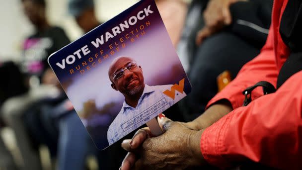 PHOTO: A supporter holds a campaign sign during a campaign rally for Georgia Democratic Senate candidate U.S. Sen. Raphael Warnock, Nov. 30, 2022 in Camilla, Georgia. (Alex Wong/Getty Images)