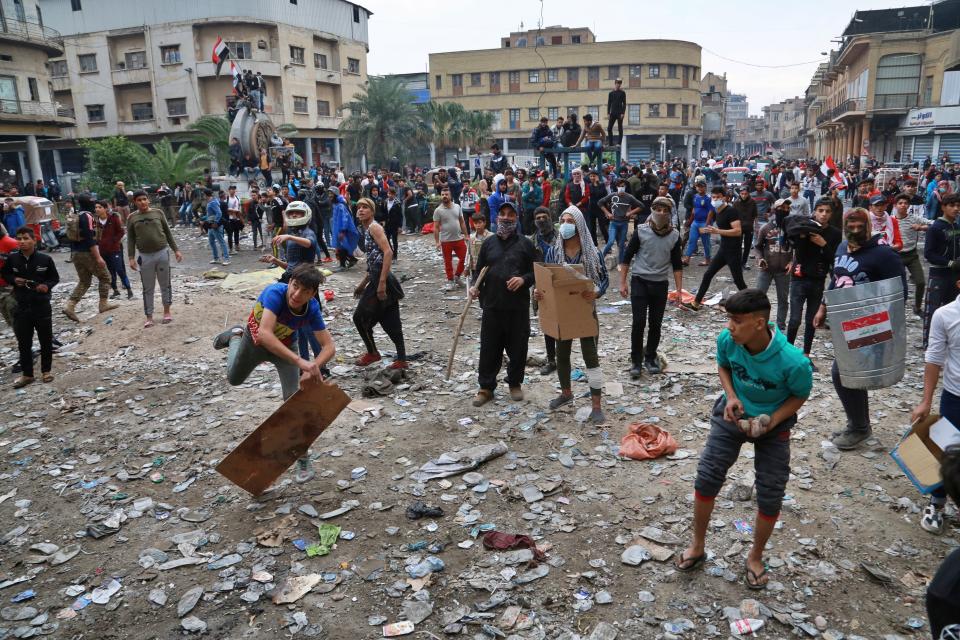 Protesters throw stones during clashes with security forces in Baghdad, Iraq, Thursday, Nov. 28, 2019. Anti-government protests have gripped Iraq since Oct. 1, when thousands took to the streets in Baghdad and the predominantly Shiite south. The largely leaderless movement is accusing the government of being hopelessly corrupt, and also decries Iran's growing influence in Iraqi state affairs. (AP Photo/Khalid Mohammed)