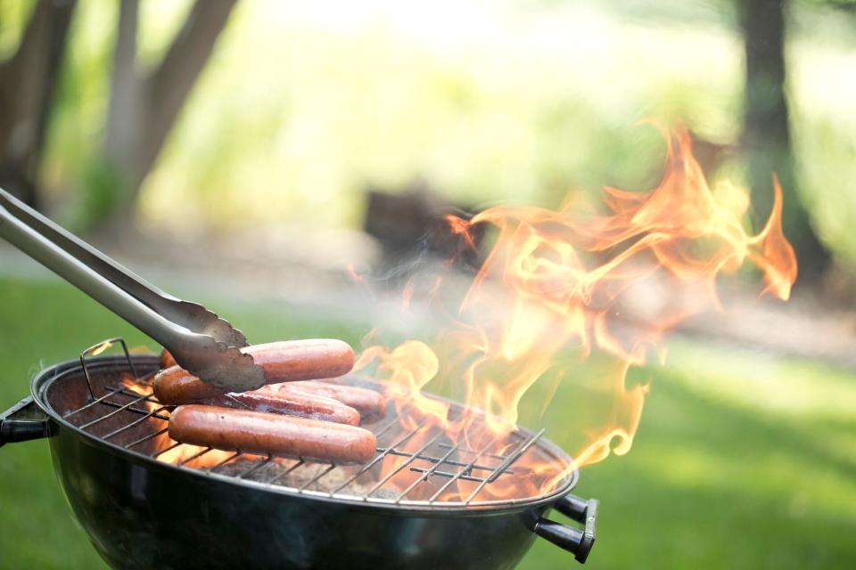 Grilling hot dogs and hamburgers outside in the summer