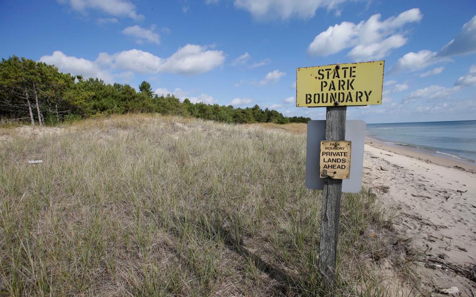 A sign marks where state park land ends and Kohler property begins at Kohler-Andrae Park, Wednesday September 26, 2018, in Sheboygan, Wis.