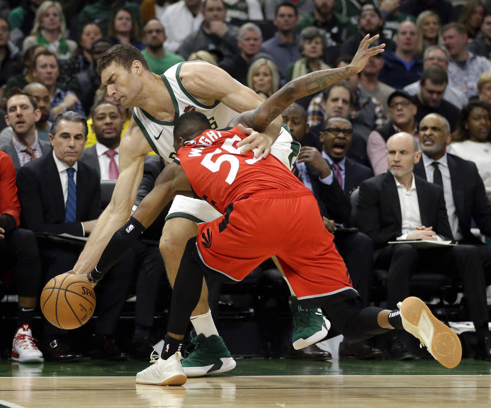 Milwaukee Bucks' Brook Lopez and Toronto Raptors' Delon Wright (55) fight for a loose ball during the first half of an NBA basketball game, Saturday, Jan. 5, 2019, in Milwaukee. (AP Photo/Aaron Gash)