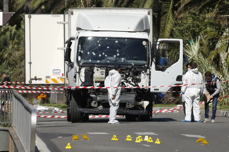 Investigators continue to work at the scene near the heavy truck that ran into a crowd at high speed killing scores who were celebrating the Bastille Day July 14 national holiday on the Promenade des Anglais in Nice, France, July 15, 2016. REUTERS/Eric Gaillard