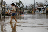 A woman wades through a flooded street after the area was hit by Hurricane Maria in Salinas, Puerto Rico, September 21, 2017. REUTERS/Carlos Garcia Rawlins