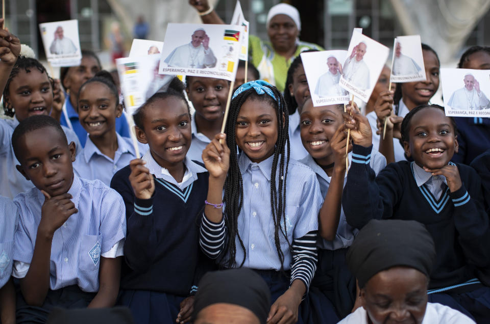 Schoolchildren wave flags as they wait to see Pope Francis, ahead of his arrival at the Apostolic Nunciature in the capital Maputo, Mozambique Wednesday, Sept. 4, 2019. Pope Francis is opening a three-nation pilgrimage to southern Africa with a strategic visit to Mozambique, just weeks after the country's ruling party and armed opposition signed a new peace deal and weeks before national elections. (AP Photo/Ben Curtis)