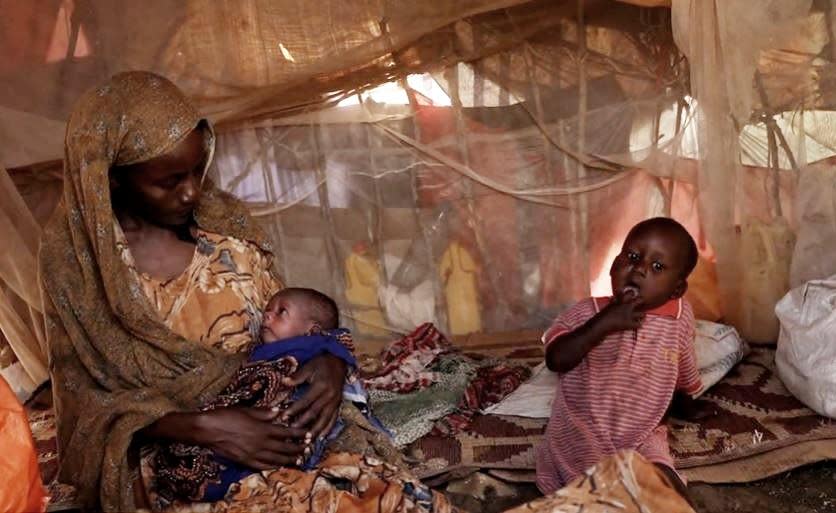 Habiba Mohammed sits in a makeshift shelter at a camp for internally displaced people in Baidoa, Somalia. She walked for six days, heavily pregnant with the son she's seen holding, to find food. / Credit: CBS News