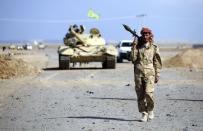 A Shi'ite fighter carries a rocket-propelled grenade launcher as he walks in the town of Hamrin in Salahuddin province March 5, 2015. REUTERS/Stringer