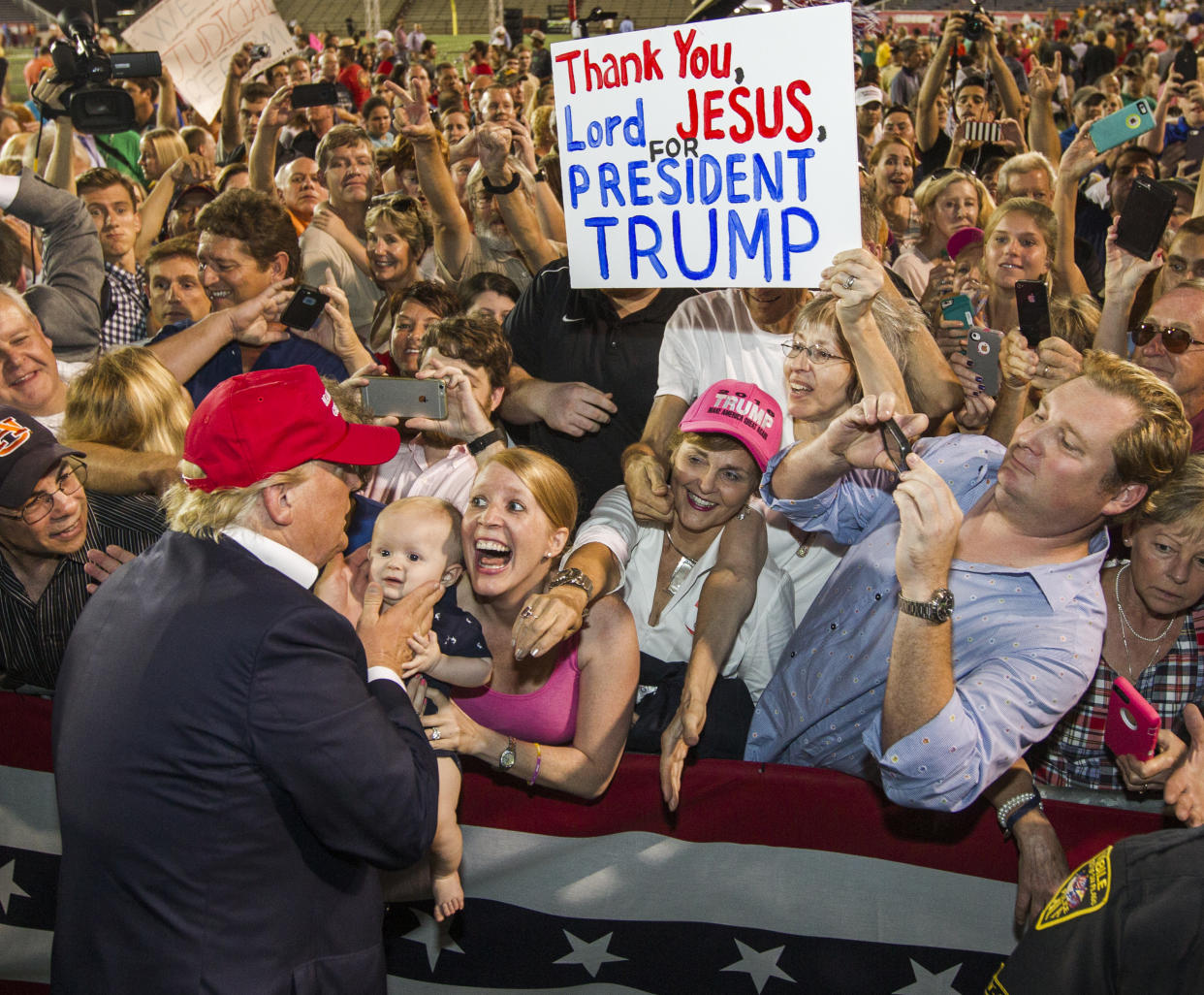 President Trump and supporters with a sign invoking religion. (Photo: Mark Wallheiser/Getty Images)