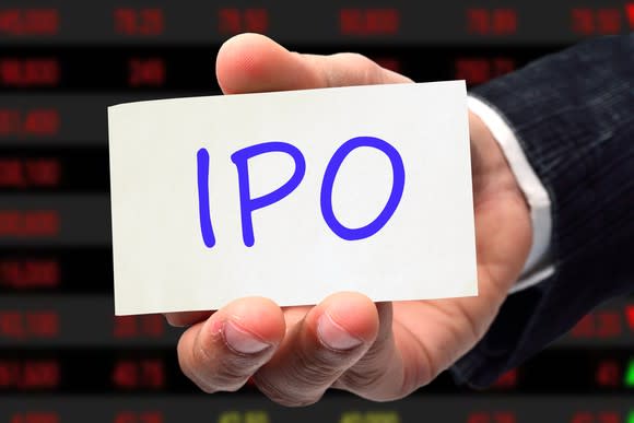 a hand of person wearing a suit holds a card saying IPO.