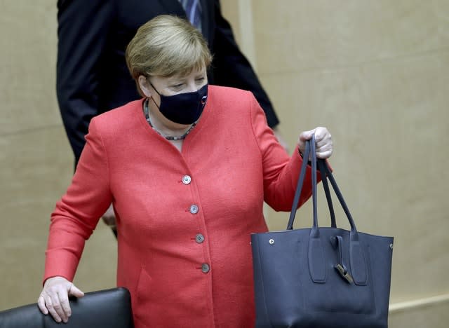 German Chancellor Angela Merkel wears a face mask as she arrives for a meeting of the upper house of the German legislative (Michael Sohn/AP)