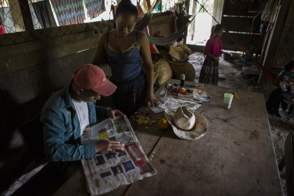 Carlos Rigoberto Caal Cux, 23, reads a newspaper article about his cousin, Jakelin Amei Rosmey Caal in Raxruha, Guatemala, on Saturday, Dec. 15, 2018. The 7-year-old girl died in a Texas hospital, two days after being taken into custody by border patrol agents in a remote stretch of New Mexico desert. (AP Photo/Oliver de Ros)