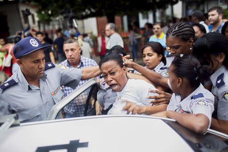 Cuban security personnel detain a member of the Ladies in White dissident group during a protest on International Human Rights Day, Havana, December 10, 2015. Cuban police detained at least six protesters shouting "Freedom" and "Long live human rights" in Havana on Thursday and dissidents reported 100 arrests nationwide on U.N. Human Rights Day, when some Cubans seek to hold unauthorized demonstrations. REUTERS/Alexandre Meneghini TPX IMAGES OF THE DAY - RTX1Y5KW