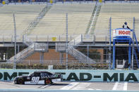 Caesar Bacarella (90) passes empty seats during a NASCAR Xfinity Series auto race Saturday, June 13, 2020, in Homestead, Fla. (AP Photo/Wilfredo Lee)