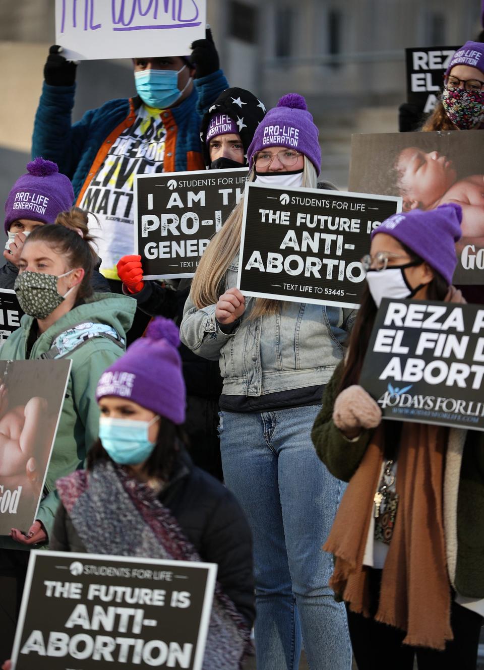 Demonstrators hold signs during an anti-abortion protest Friday, Jan. 29, 2021 at Monument Circle in downtown Indianapolis.